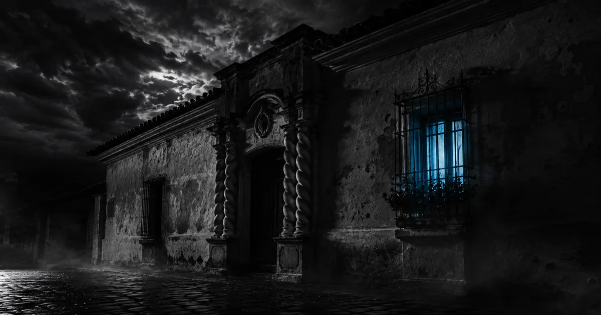 Fachada colonial de la Casa Histórica de Tucumán de noche, con una ventana enrejada iluminada por una luz azul espectral